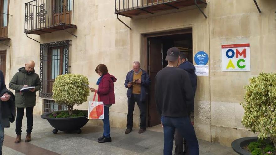 Usuarios de la Oficina Municipal de Atención al Ciudadano de la Plaça de Baix aguardando ayer su turno en la calle.