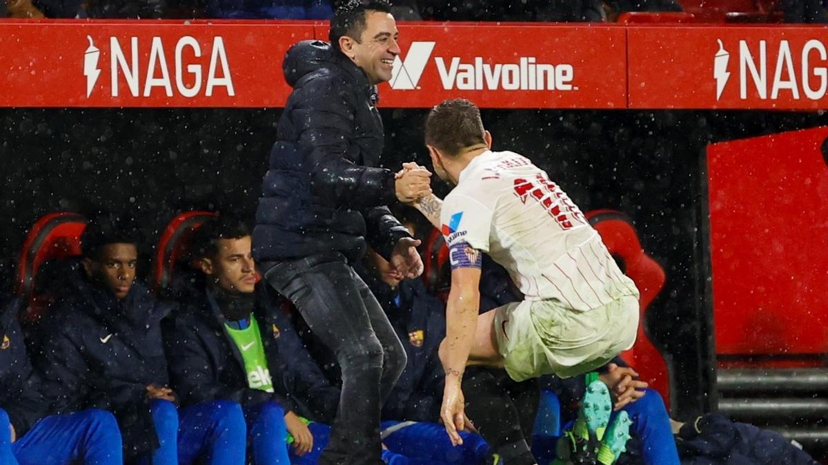 Xavi ayuda a levantarse a Rakitic, su viejo compañero en el Barça.