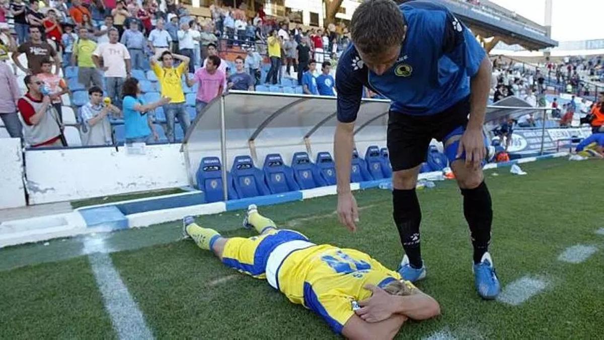 Un jugador herculano intenta consolar a un cadista tras la consumación del descenso de los amarillos en el Rico Pérez, en el 2008.