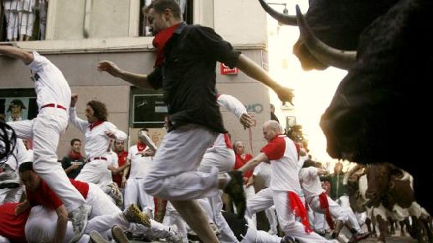 Los mozos corren ante los cabestros en el sexto encierro de San Fermín.