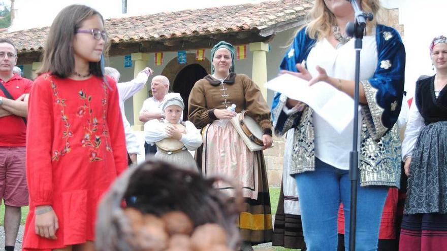 Mariola Menéndez y su hija, Luna, durante el pregón; a la derecha, Roberto Díaz Arce, con el premio, y tras él, el párroco Agustín Hevia Ballina, en Camoca.