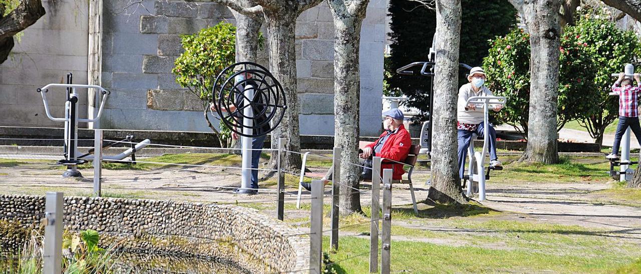 Un mayor y un niño se ejercitan en el parque biosaludable del centro de Cangas. |   // GONZALO NÚÑEZ