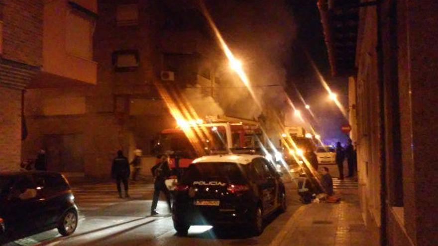 A la derecha un hombre es atendido con una mascarilla y al fondo la columna de humo