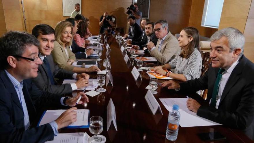 Momento previo a la reunión de los equipos negociadores de PP y Ciudadanos; a la izquierda, los populares, con Álvaro Nadal en primer término; junto a él, José Luis Ayllón, Fátima Báñez, Fernando Martínez-Maillo, Andrea Levy, José Antonio Bermúdez de Castro y Dolors Montserrat; frente a ellos, en representación de Ciudadanos, al fondo, Toni Roldán; a su lado Juan Carlos Girauta, Miguel Gutiérrez, José Manuel Villegas, Melisa Rodríguez y Luis Garicano, en primer término.