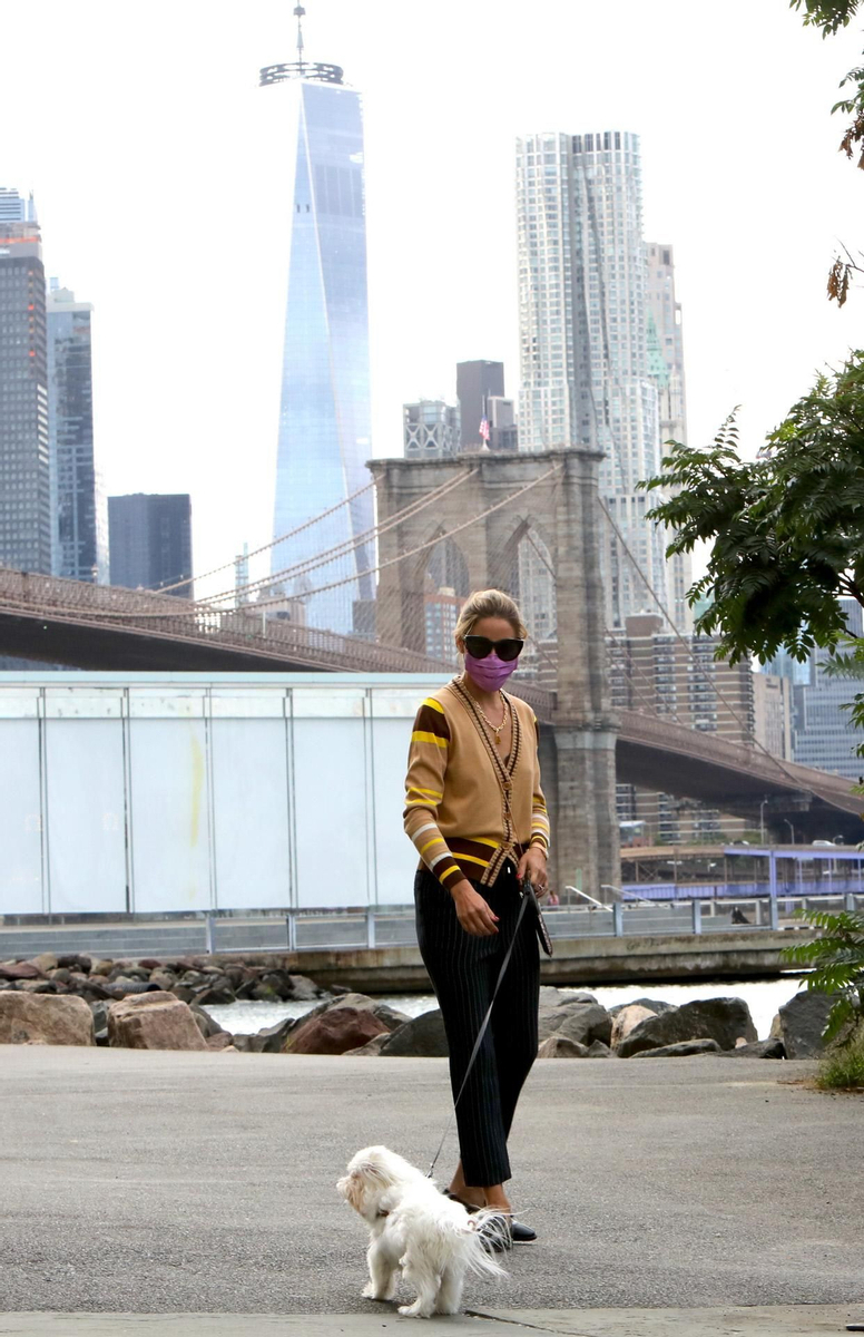 Olivia Palermo con chaqueta de punto, pantalones de rayas y mocasines