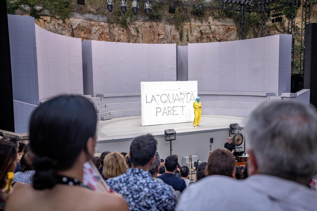 Una 'Marta Pazos' con peluca azul y chándal amarillo, en el escenario del Grec durante la inauguración del Festival de Verano de Barcelona, este lunes.