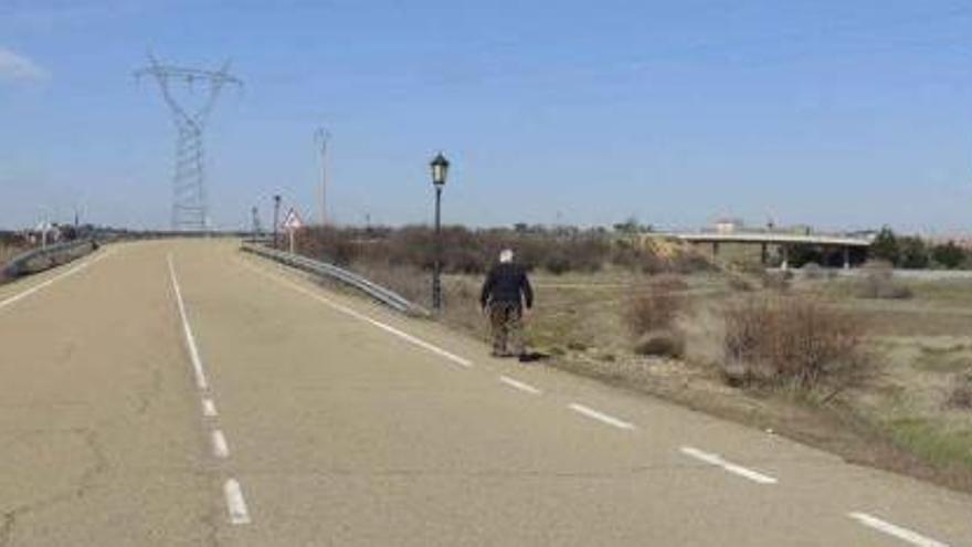 Un vecino transita por el arcén de la carretera de Junquera a La Milla de Tera.