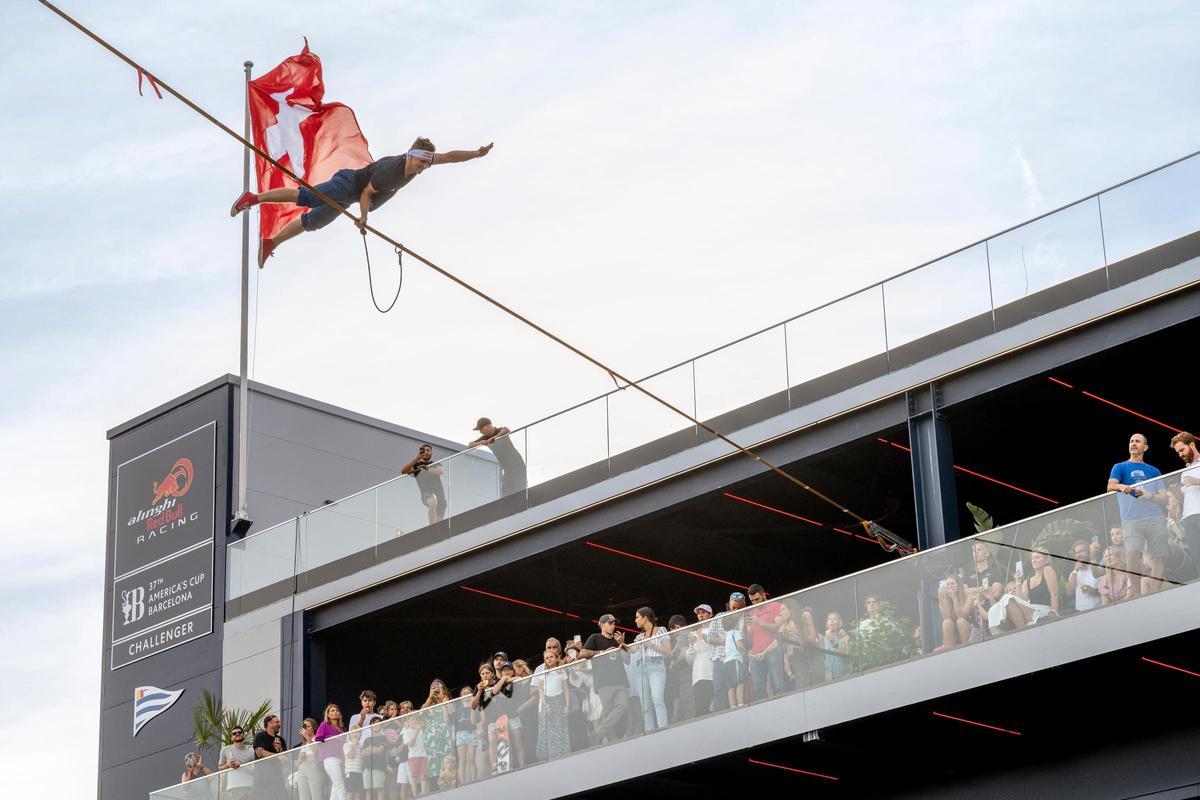 Un atleta de Red Bull en una demostración de 'slackline' en el estreno de la base del equipo suizo de la Copa América de vela, en Barcelona.