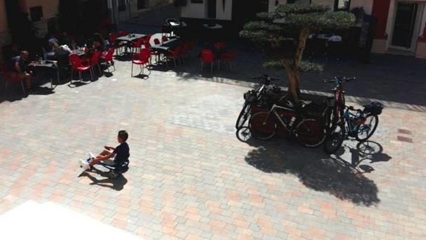 Un niño juega con un patinete en la plaza del Ayuntamiento.