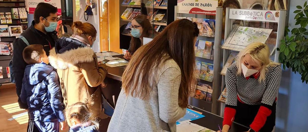 Una familia se interesa por la oferta de Priego en la Oficina Municipal de Turismo.