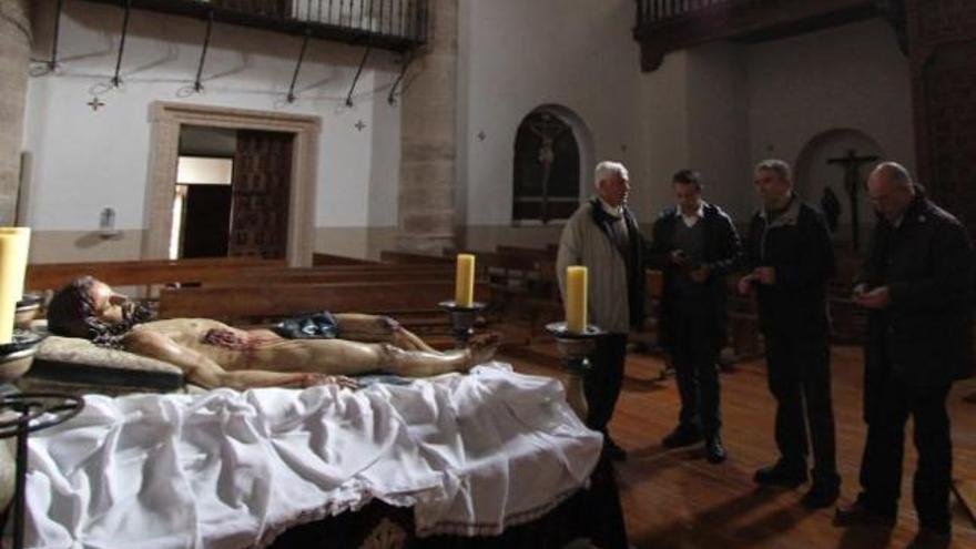 Varios hermanos observan el Yacente en la iglesia de San Andrés.