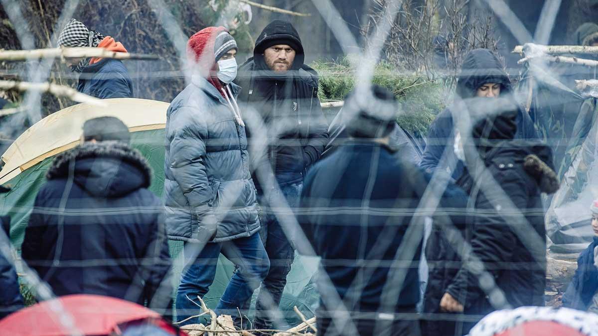 Migrantes tras la valla fronteriza en Bielorrusia, cerca del paso fronterizo de Kuznica, entre Polonia y Bielorrusia