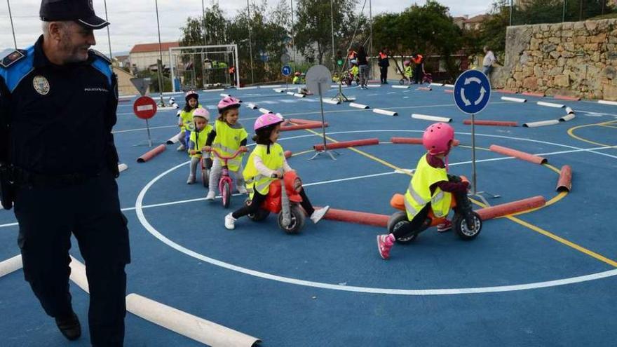 Un policía de Moaña controla la circulación de los niños en el circuito en Quintela. // Gonzalo N.