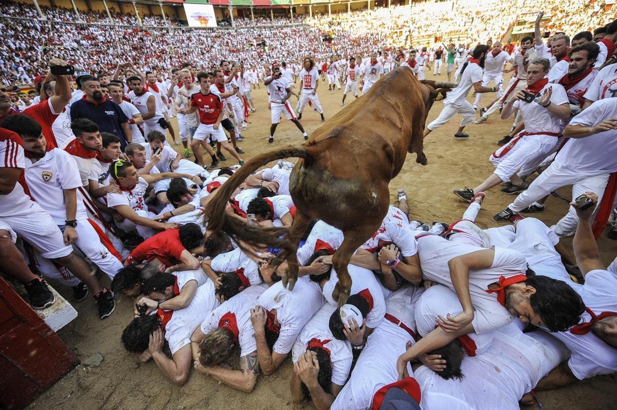 Un astado salta sobre los mozos a la entrada de la plaza de toros de Pamplona en el tercer encierro de San Fermín 2016.