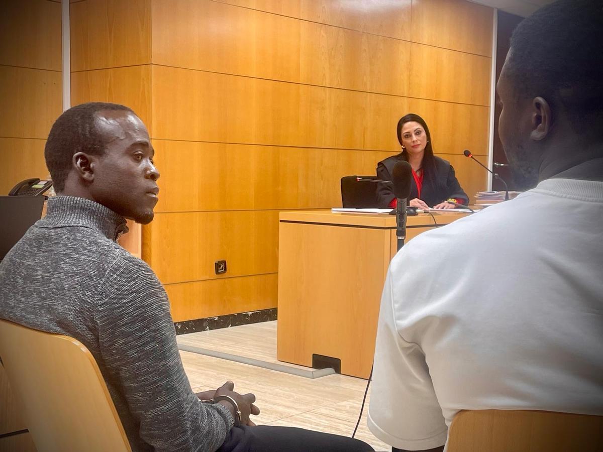 El migrante atiende al intérprete que le traduce las preguntas de su abogada durante el juicio en la Audiencia Provincial de Santa Cruz de Tenerife.
