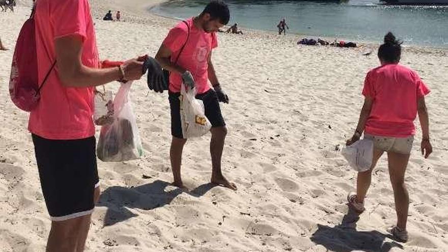 Voluntarios en la playa de Rodas, durante una jornada de recogida de residuos en Cíes en 2017. // FdV