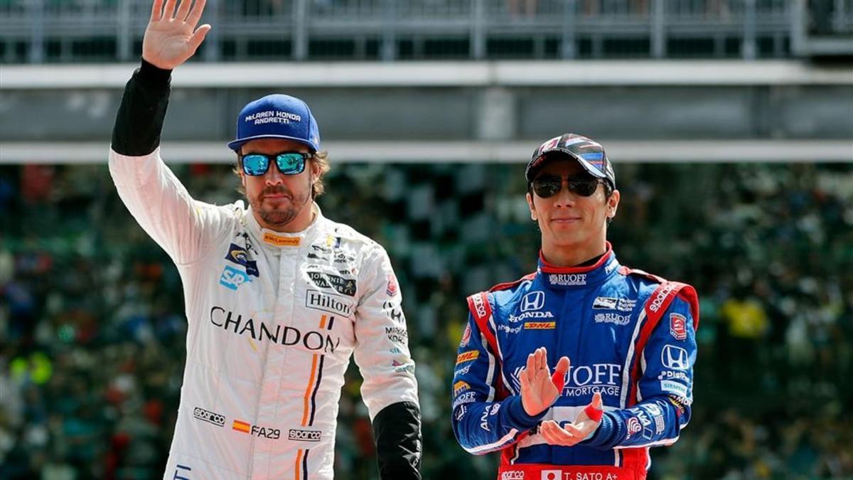 Alonso saludando al público junto a Takuma Sato, el vencedor de las 500 Millas