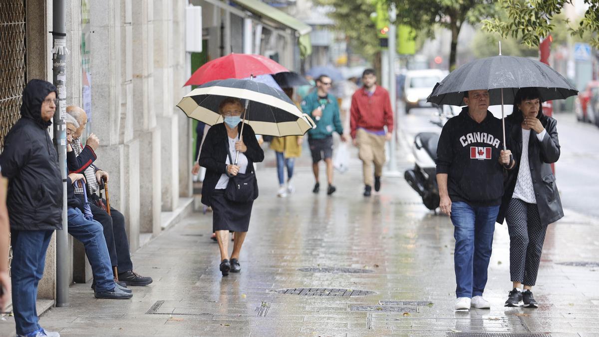 Gente con paraguas esta mañana en Vigo