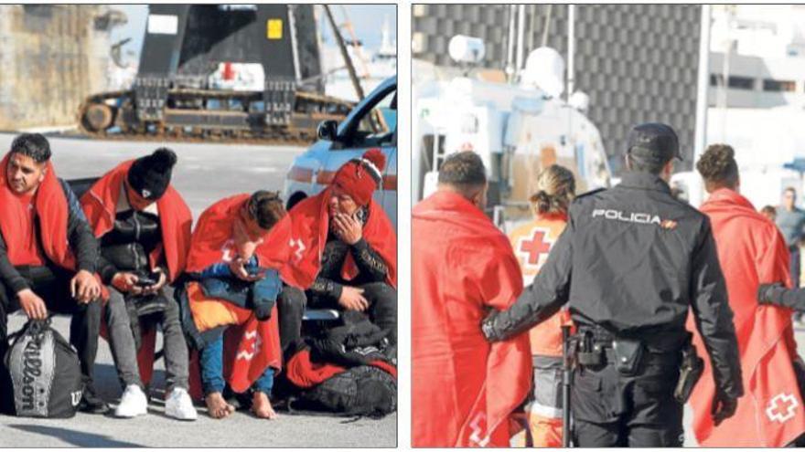 Algunos de los inmigrantes, ayer, tras su llegada al puerto alicantino. A la derecha, la Policía conduce a dos de los inmigrantes.