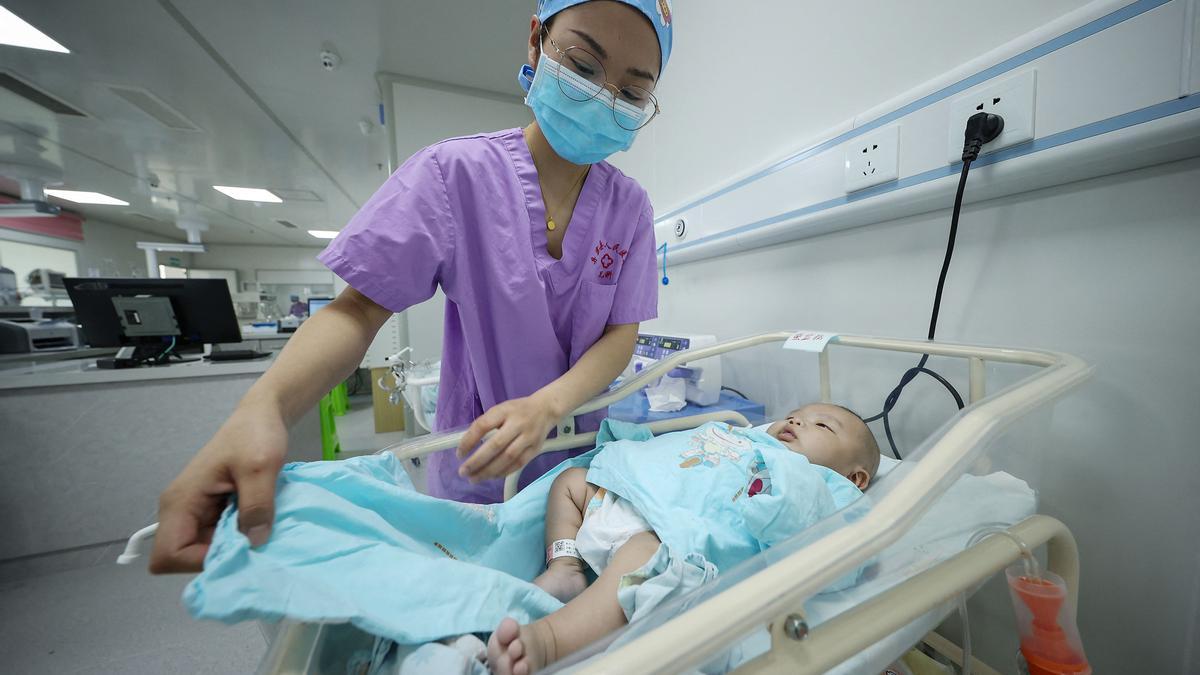 Una enfermera arropa a un bebé en el hospital de Danzhai, en la provincia china de Guizhou, este martes.