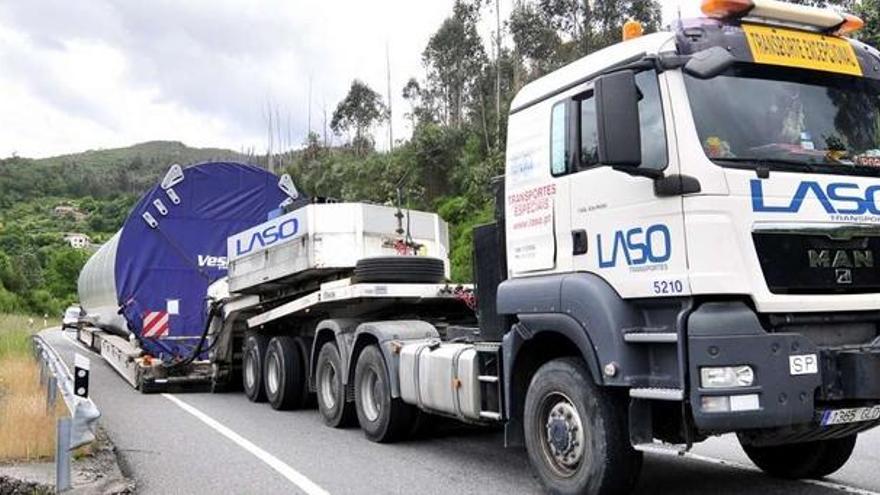 El transporte especial, con la base del aerogenerador eólico sobre el asfalto, ayer en Cotobade.