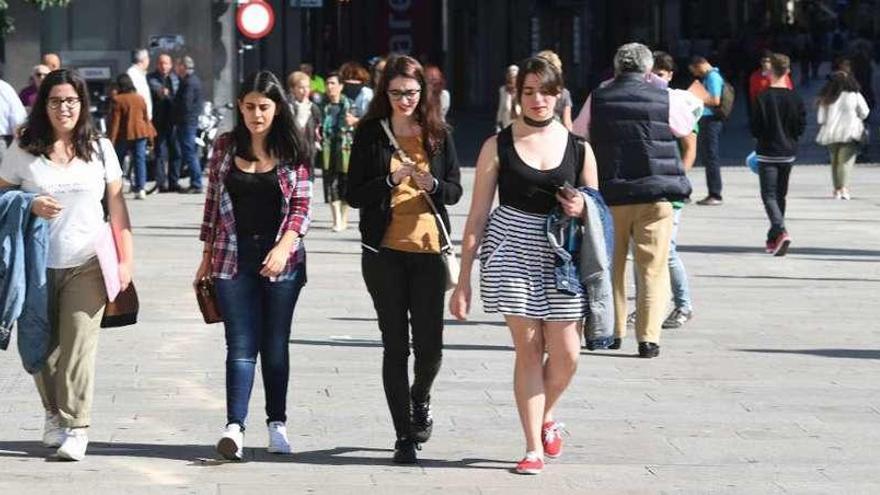 Un grupo de jóvenes camina, ayer, bajo el sol en el centro de A Coruña. // Víctor Echave