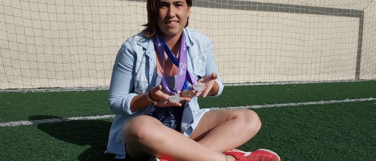 La mallorquina Cata Coll muestra sobre el césped de Son Caulelles las tres medallas que ha conseguido en su carrera como profesional.