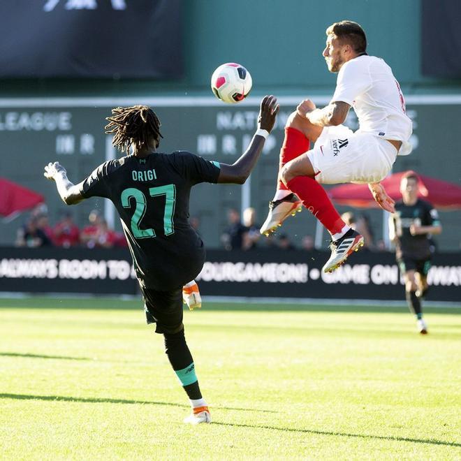 Divok Origi (I) del Liverpool y Manuel Agudo Duran (D) del Sevilla lucha por el balón durante el partido amistoso disputado en el Fenway Park en Boston, Massachusetts.