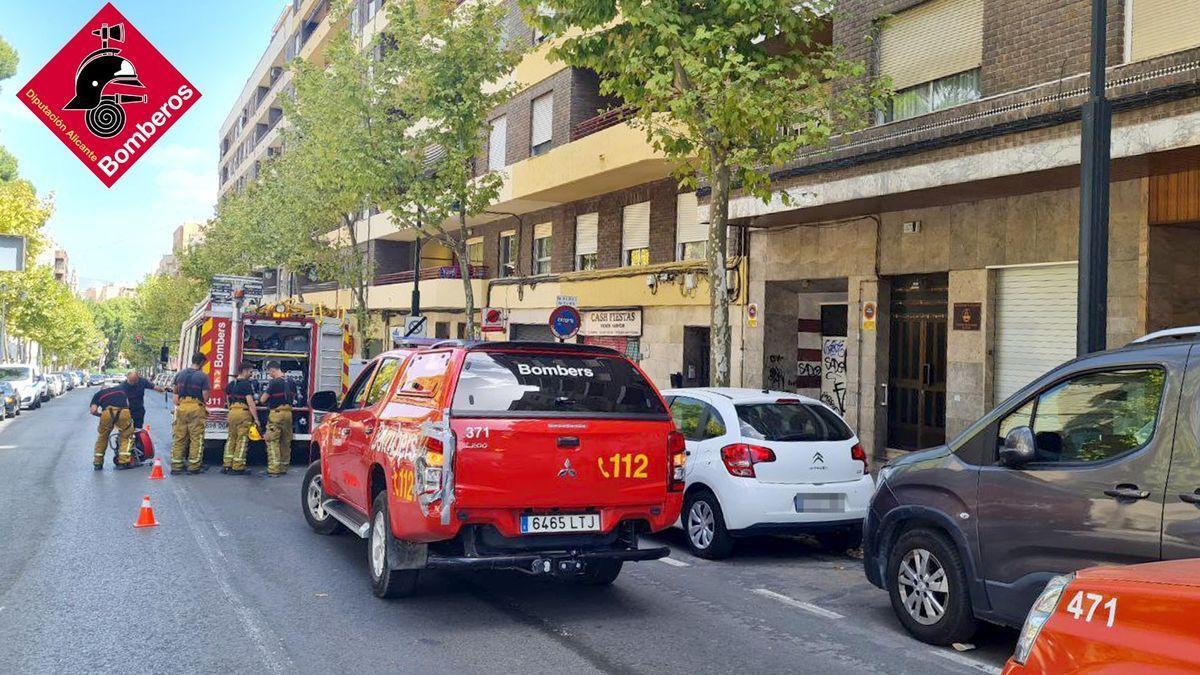 Cuatro bomberos, en la calle de Alcoy en la que se ha incendiado la vivienda.