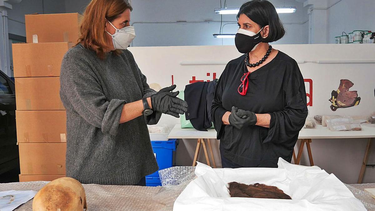 En la imagen principal, Nona Perera y la arqueóloga Verónica Alberto junto a los restos. Debajo, detalle del estado de conservación de las trenzas halladas en La Chifletera y el cráneo de Los Jameos del Agua.