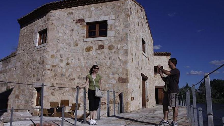 Dos visitantes se fotografían en las aceñas de Olivares.