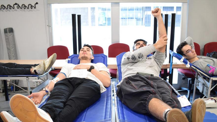Tres universitaris donant sang