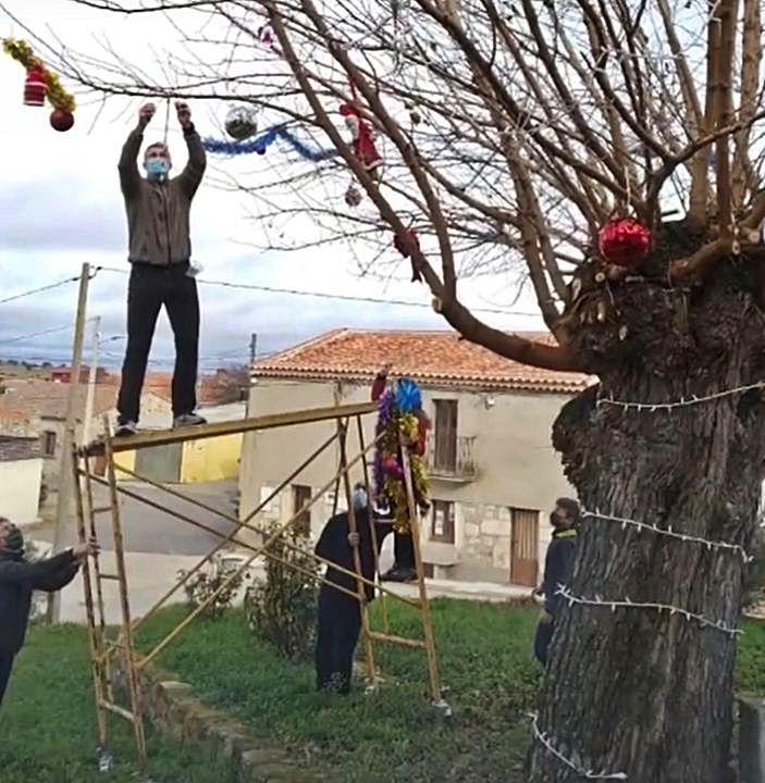 Vecinos trabajan en equipo en la decoración del árbol
