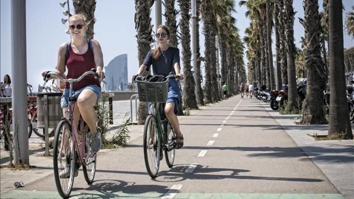 Unos ciclistas circulan por el carril bici ubicado frente al Hospital del Mar, en la Vila Olímpica de Barcelona.