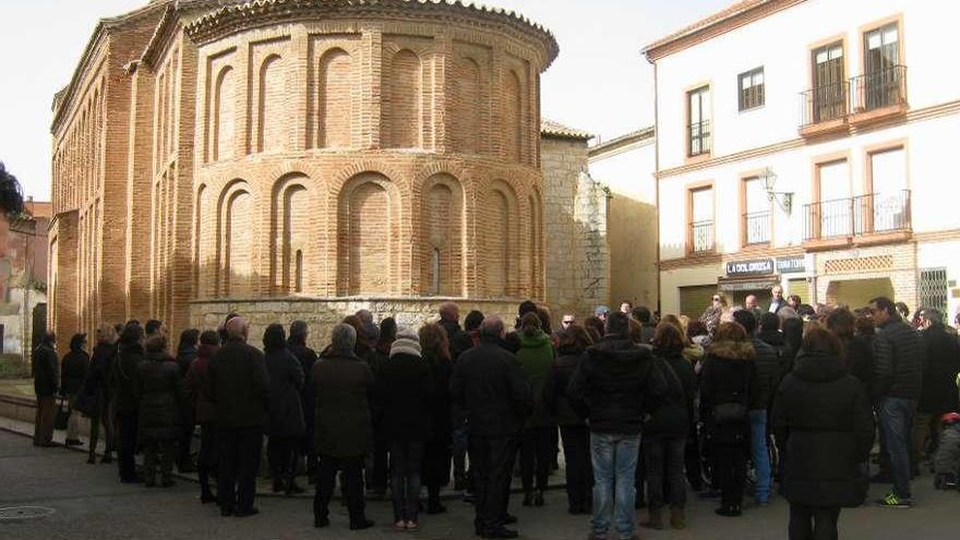 Turistas admiran la iglesia de San Lorenzo el Real que ha sido dotada de iluminación ornamental.