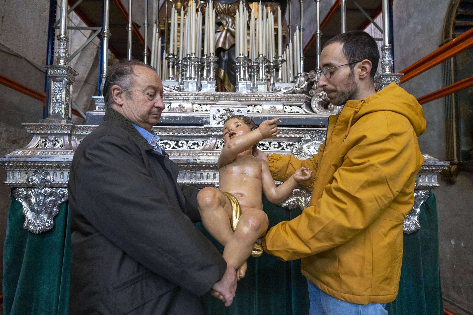 El presidente de la cofradía, Pedro Barceló, y el historiador del arte Juan José Soler muestran uno de los cuatro ángeles que lleva el paso.