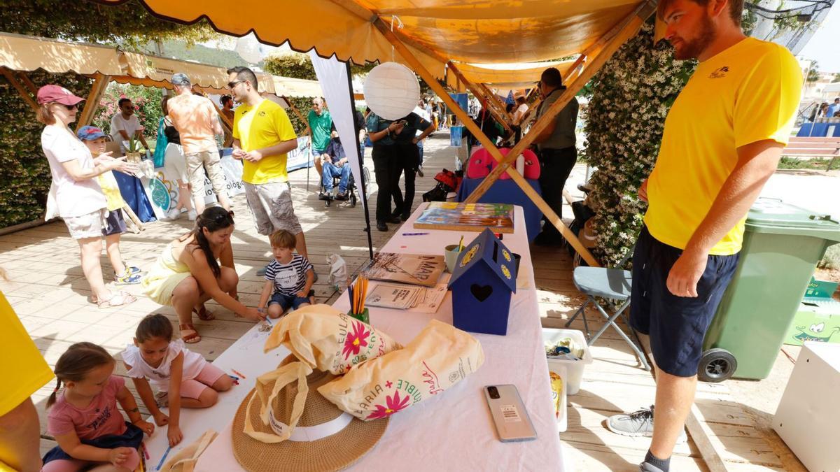 Un grupo de niños se divierte pintando en uno de los puestos de la feria de medio ambiente. | J. A. RIERA