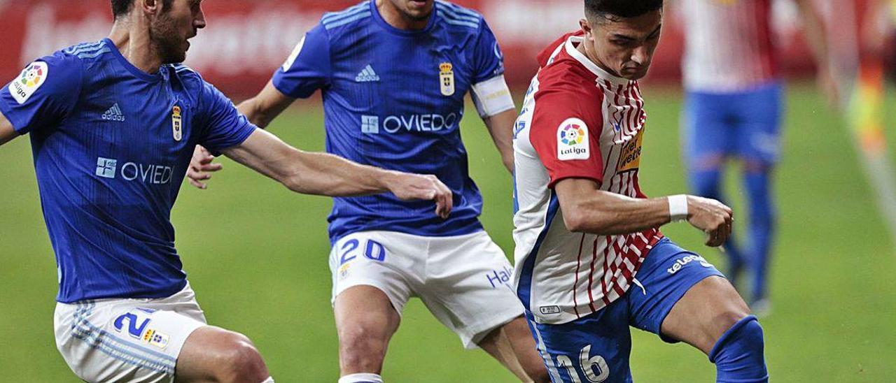 Manu García conduce la pelota, perseguido por Lucas y Tejera.