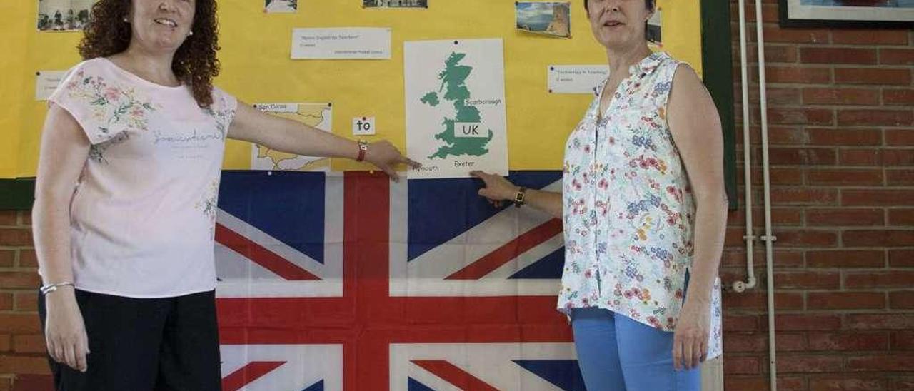 María Covadonga Paredes y María Luisa Pérez señalan Plymouth y Exeter en un mapa de Reino Unido colgado en el vestíbulo del colegio de San Cucao.