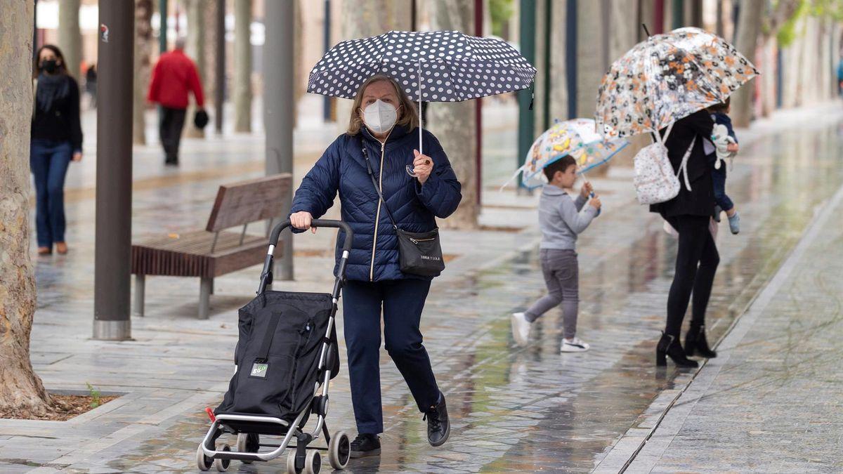 Ciudadanos resguardándose de la lluvia bajo el paraguas.