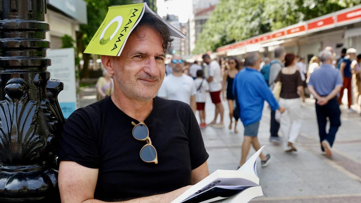 Jaime Priede, con unos libros, en el paseo de Begoña de Gijón.