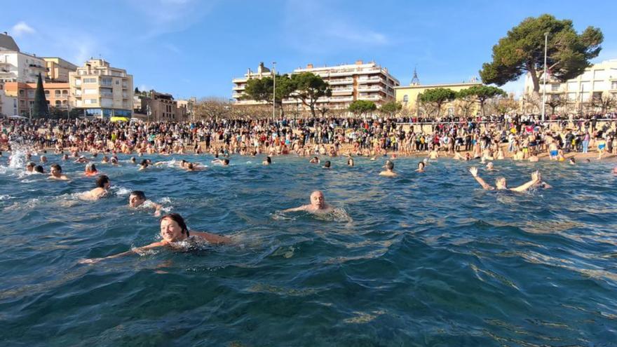 Mig miler de persones participen en el primer bany de l’any a la platja a Sant Feliu