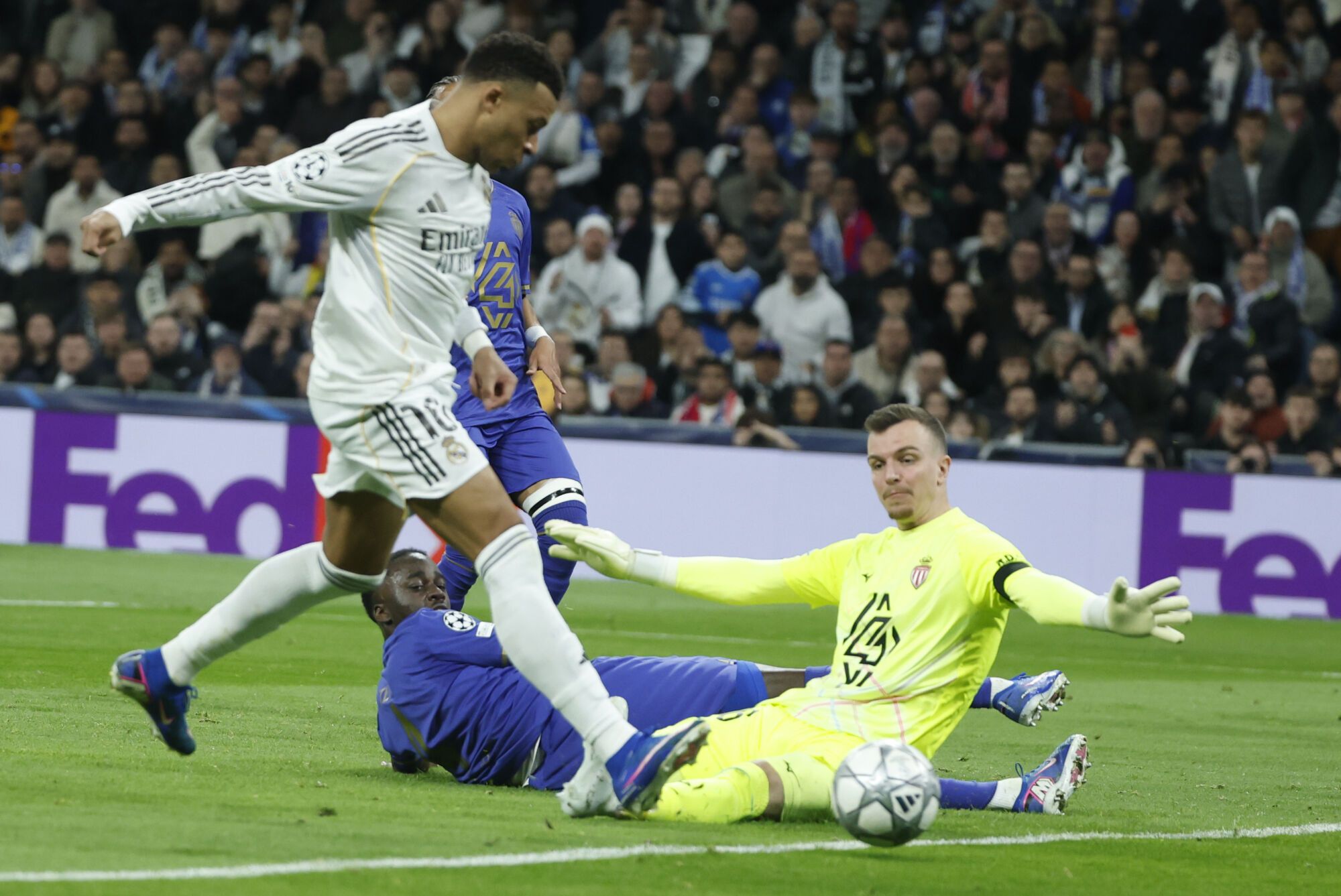 El delantero francés del Real Madrid, Kylian Mbappé (i), intenta batir al portero alemán del AS Mónaco Philipp Köhn durante el encuentro correspondiente a la Liga de Campeones que disputan Real Madrid y el AS Mónaco, en el estadio Santiago Bernabéu en Madrid. EFE/Juanjo Martín. (REAL MADRID)