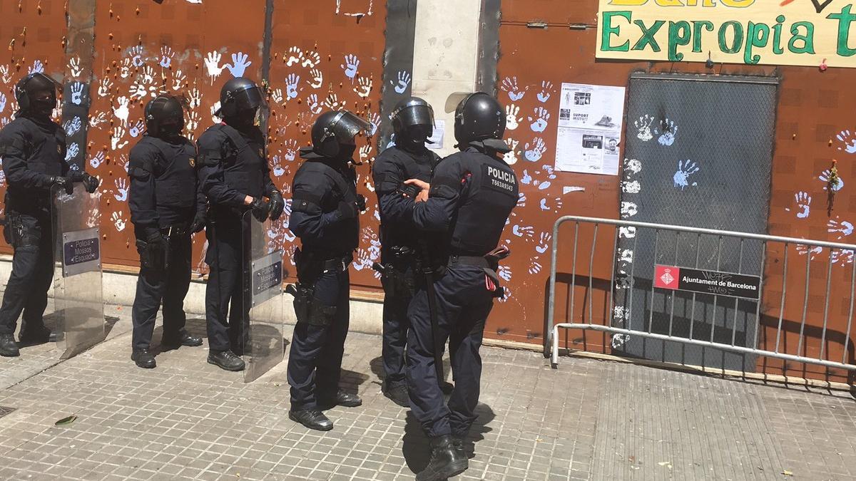 Antidisturbios de los Mossos, frente al local del 'banco expropiado' de Gràcia, este domingo.