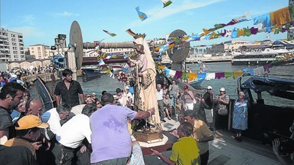 Vecinos de la Barceloneta embarcan la imagen de la virgen, en el 2010.