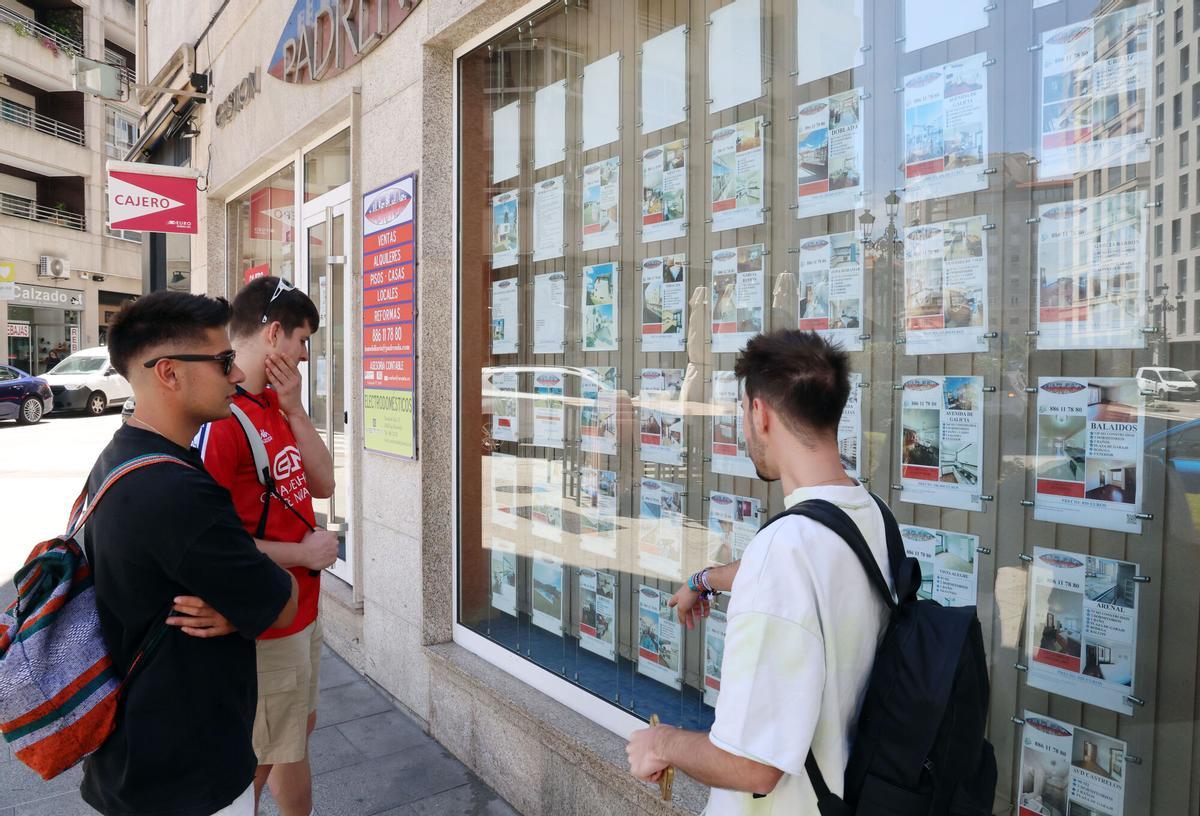 Jóvenes viendo en una inmobiliaria anuncios de viviendas, casas y pisos en alquiler (o venta), especialmente escasos para universitarios.