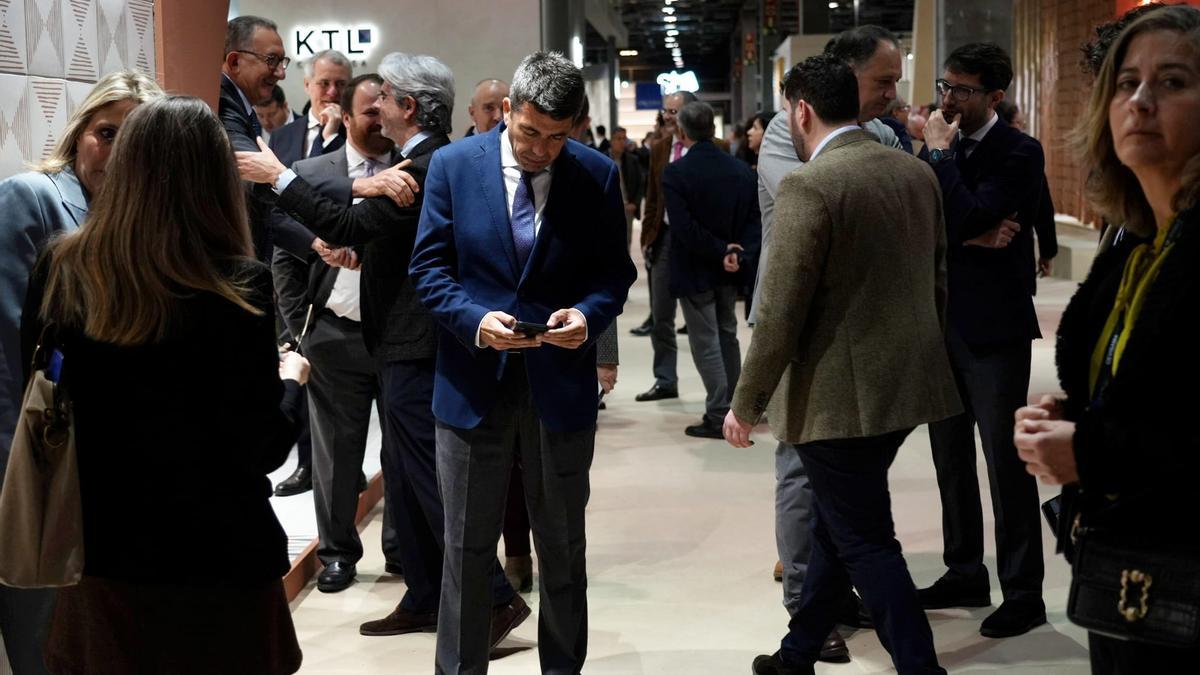 Mazón atiende su teléfono en su visita a la feria Cevisama hoy