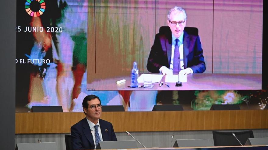 El presidente de la CEOE, junto a una pantalla con Pablo Isla en imagen durante el encuentro telemático de la CEOE.