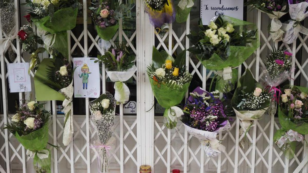 Flores dejadas por vecinos en el local de la víctima, en Lugo.  | // EFE