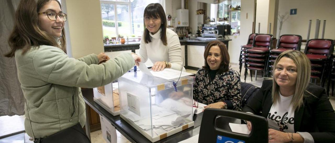 Elena Elola Pastor vota, al lado de un bucle magnético, en el centro social de Vallobín (Oviedo). En la mesa electoral, de izquierda a derecha, Katia Villalta (presidenta), Felícitas Ramos y Páz Pérez.